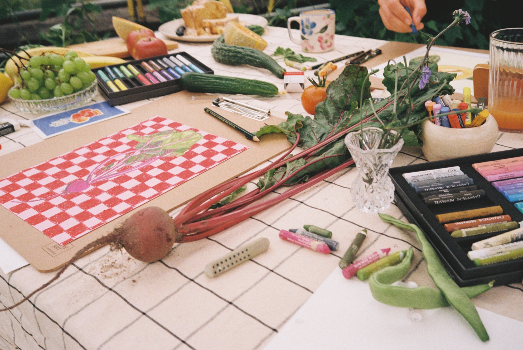 Ölpastellkreiden, Gemüse und Zeichnungen auf dem Workshoptisch