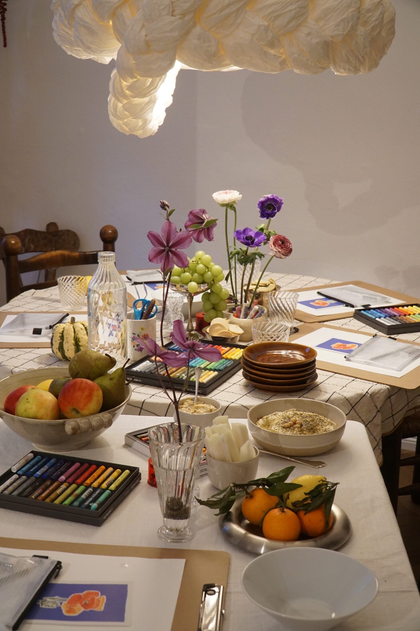 Vorbereiteter Workshoptisch mit Blumen, Obst und Ölpastellkreiden bei HUMAN NEST